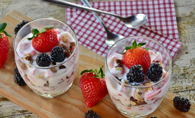 two cups of yogurt with berries and nuts