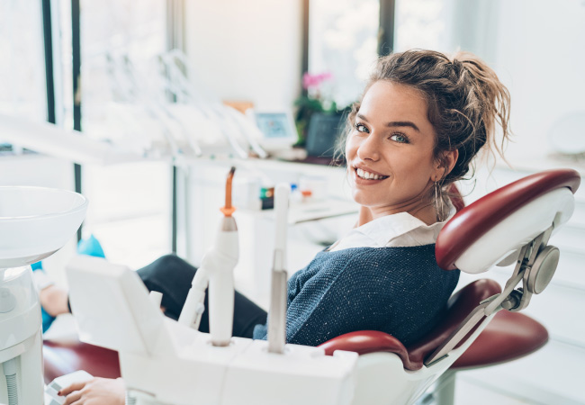 Brunette woman about to receive dental sedation sits calmly in the dental chair at the dentist